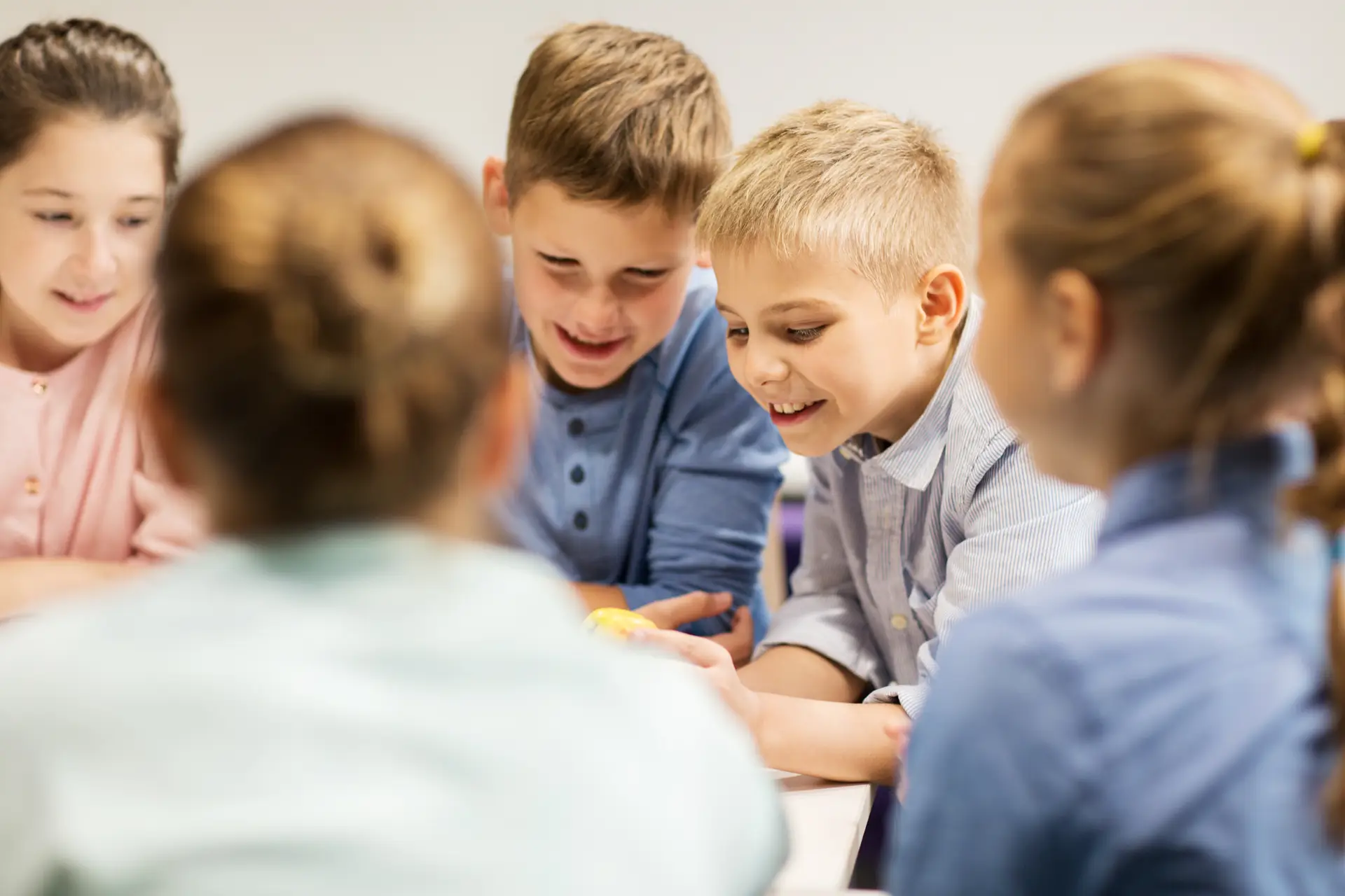 Profesora de inglés enseñando a niños con materiales didácticos coloridos.